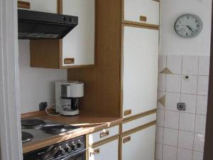 cocina con fogones y reloj en la pared en Ferienwohnung Behrens-Reinke en Albstadt