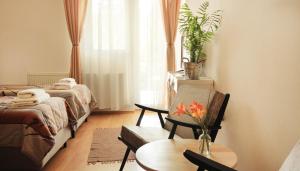 a room with two beds and a table with a vase of flowers at Vila Dunavski Raj in Golubac