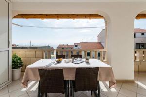 a table and chairs on a balcony with a view at Apartments Sena in Bol