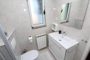 łazienka z umywalką, toaletą i lustrem w obiekcie Apartments Tanja w Rovinj +37 zdjęć
