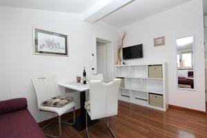 salon z biurkiem, stołem i krzesłami w obiekcie Apartments Tanja w Rovinj