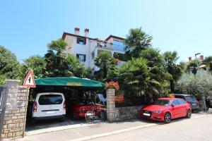 dwa samochody zaparkowane przed budynkiem w obiekcie Apartments Tanja w Rovinj