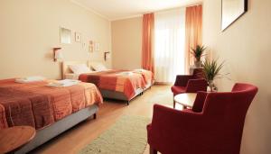 a hotel room with two beds and two chairs at Vila Dunavski Raj in Golubac
