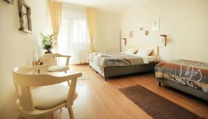 a bedroom with two beds and a chair in it at Vila Dunavski Raj in Golubac