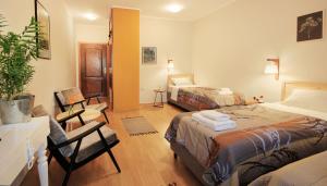 a hotel room with two beds and a living room at Vila Dunavski Raj in Golubac