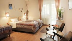 a hotel room with two beds and a chair at Vila Dunavski Raj in Golubac