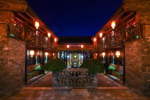 平遥Elsewhere Hotel The former residence of the draft bank的一座建筑的庭院,晚上有灯