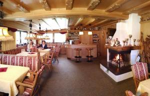 un restaurante con chimenea en el centro de la habitación en Garni Waltoy, en Selva di Val Gardena