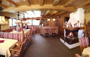 a restaurant with a fireplace in the middle of the room at Garni Waltoy in Selva di Val Gardena