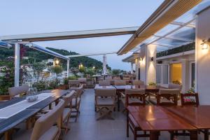 a restaurant with tables and chairs on a patio at Olympic Hotel in Parga