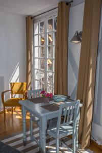 una mesa azul y sillas en una habitación con ventana en L'Hallai du Roy, en Le Mans