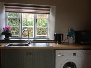 a kitchen counter with a sink and a window at The Studio in Wiveliscombe