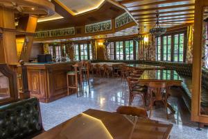 a restaurant with tables and chairs and a bar at Park Hotel Izvorite in Kotel