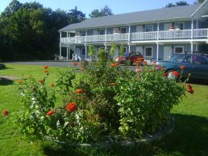 a house with a flower garden in front of it at Americas Best Value Inn Scarborough Portland in Scarborough