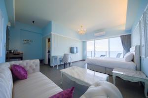 een hotelkamer met twee bedden en een bank bij Whitecaps B&B in Yanliau