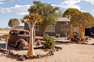 um carro velho estacionado em frente a um edifício em Gondwana Canyon Roadhouse em Stamprivier