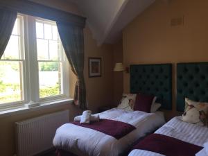 a bedroom with two beds and two windows at The Rambler Inn & Holiday Cottage in Edale