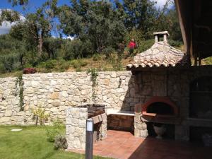 een stenen oven in een tuin met een stenen muur bij Dimorra Country House in Castelvenere