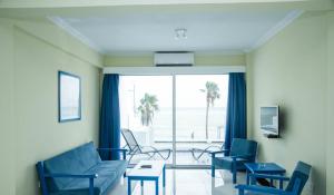 una sala de estar con muebles azules y vistas al océano. en Paphinia SeaView Apartments en Pafos