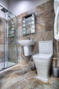 a bathroom with a toilet and a sink and a shower at Bertram's in Warkworth