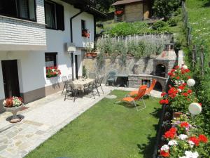 a patio with a table and chairs and flowers at Apartma Jezero in Most na Soči