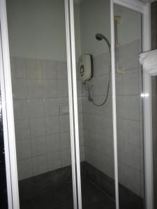 y baño con ducha y puerta de cristal. en Langkah Syabas Beach Resort, en Kinarut