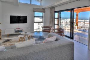 a living room with a couch and a tv at Azure 216 in Bloubergstrand