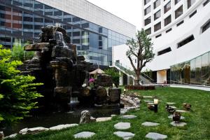 una fuente en un parque frente a un edificio en Beijing International Hotel, en Beijing