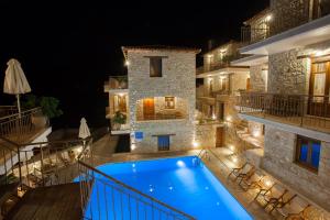 a villa with a swimming pool at night at Anigraia in Paralio Astros