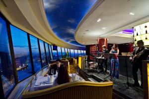 a group of people playing instruments in a room with windows at Beijing International Hotel in Beijing