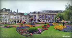 a park with flowers in front of a building at Le Studio by La Reine City Center in Spa