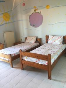 two beds in a room with a wall with a sun at Koutrakis House in Iliopoulaíika