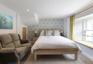 a bedroom with a bed and a chair at Bertram's in Warkworth