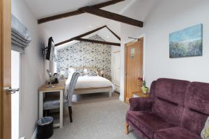 a bedroom with a bed and a purple couch at Bertram's in Warkworth