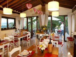 - une salle à manger avec des tables, des chaises et des fenêtres dans l'établissement Agriturismo Sant'illuminato, à Calzolaro
