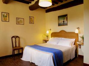 een slaapkamer met een groot bed en een stoel bij Agriturismo Sant'illuminato in Calzolaro