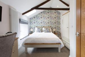 a bedroom with a bed with a floral wall at Bertram's in Warkworth