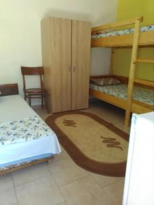 a bedroom with two bunk beds and a chair at Casa Stelutele Marii in Costinesti