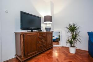 a television on a wooden cabinet in a living room at Apartman Mila in Poreč