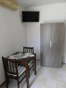 a dining room with a table and chairs and a television at Napház Apartman in Tiszafüred