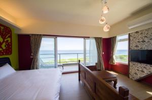 een slaapkamer met een bed en uitzicht op de oceaan bij Whitecaps B&B in Yanliau
