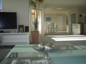 a living room with a glass table and a tv at Seascape Villa B&B in Tauranga