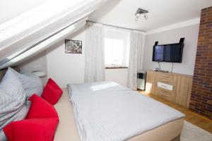 a bedroom with a bed and a red couch at Spreewald-Ferienwohnung Reschke in Radensdorf