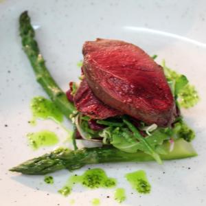 a piece of meat on a white plate with asparagus at The Bath Arms Hotel in Cheddar