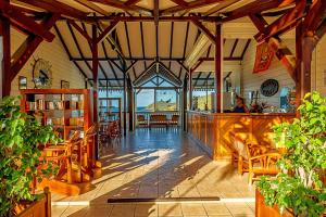 une grande salle avec une bibliothèque dotée de tables et de chaises dans l'établissement Hôtel Résidence Océane, à Tartane