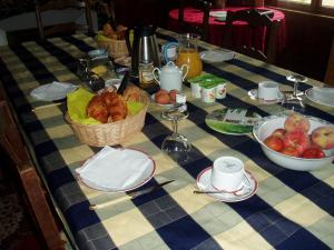 una mesa con cestas de pan y fruta. en Chateau des poteries, en Fresville