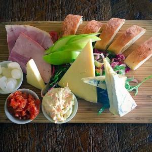 a tray of different types of cheese and bread at The Bath Arms Hotel in Cheddar