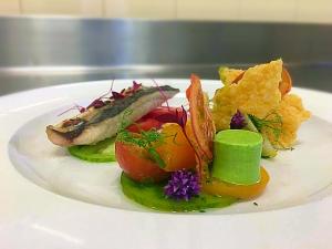 a plate of food with a fish and vegetables at The Bath Arms Hotel in Cheddar