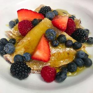 a plate of french toast with fruit on it at The Bath Arms Hotel in Cheddar
