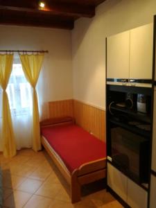 Mały pokój z łóżkiem i kuchenką mikrofalową w obiekcie Guliba Vendégház w Bogácsu +37 zdjęć